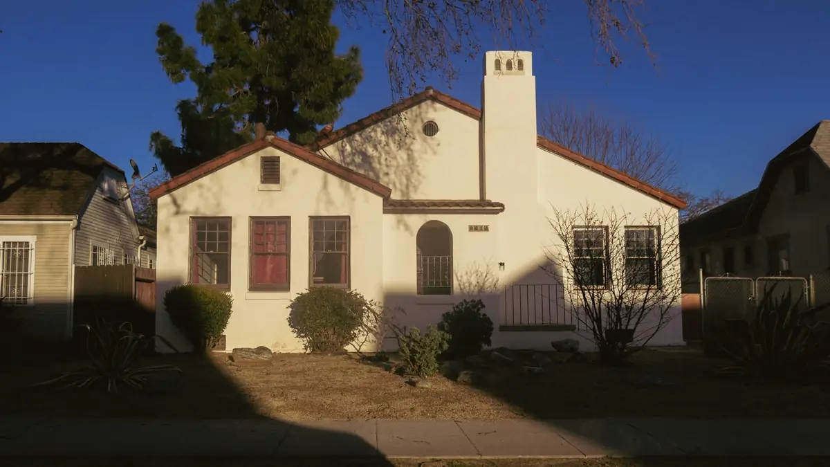Single-story Spanish-style bungalow with a tile roof in evening light