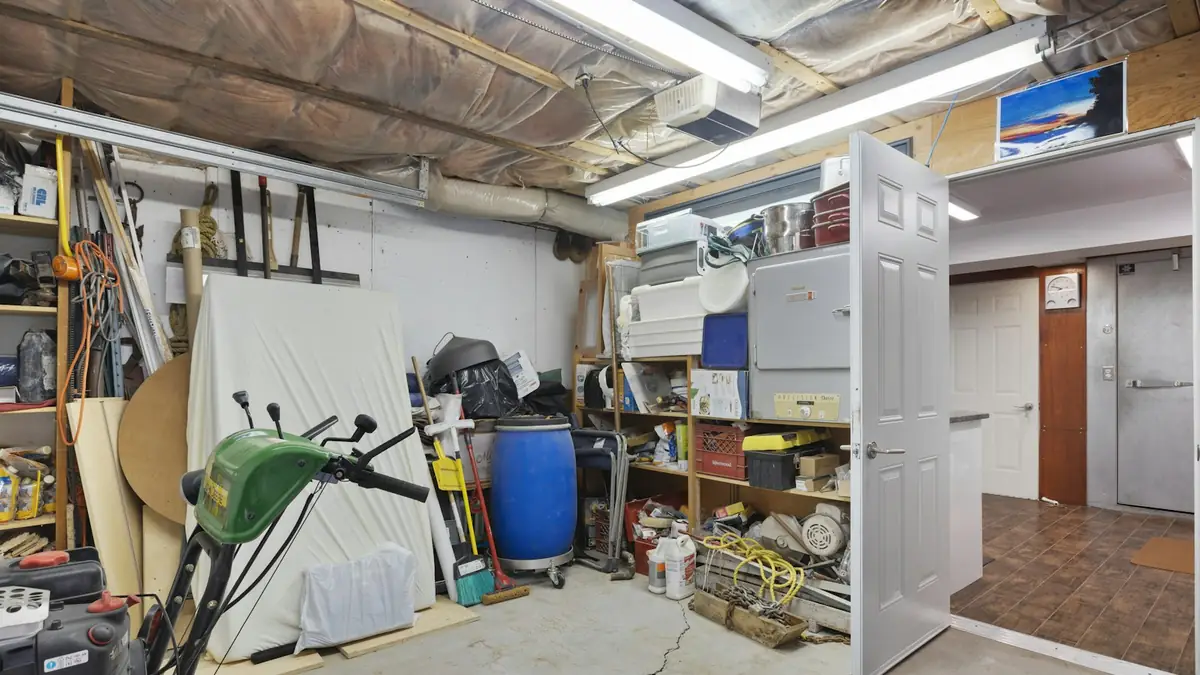 Inside a packed two-car garage with shelves and stored gear